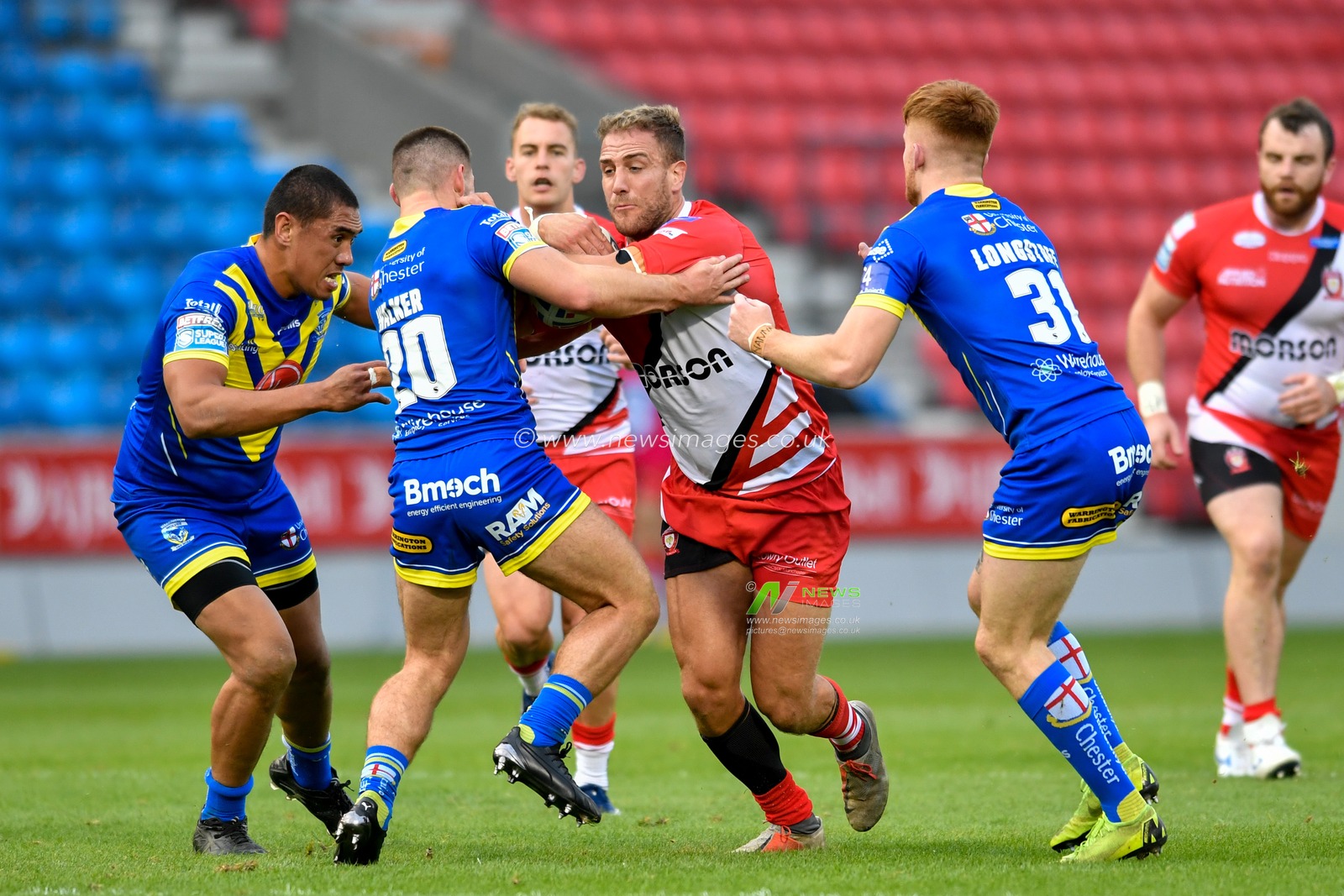 Lee Mossop (8) of Salford Red Devils is tackled by Danny Walker (20) of Warrington Wolves