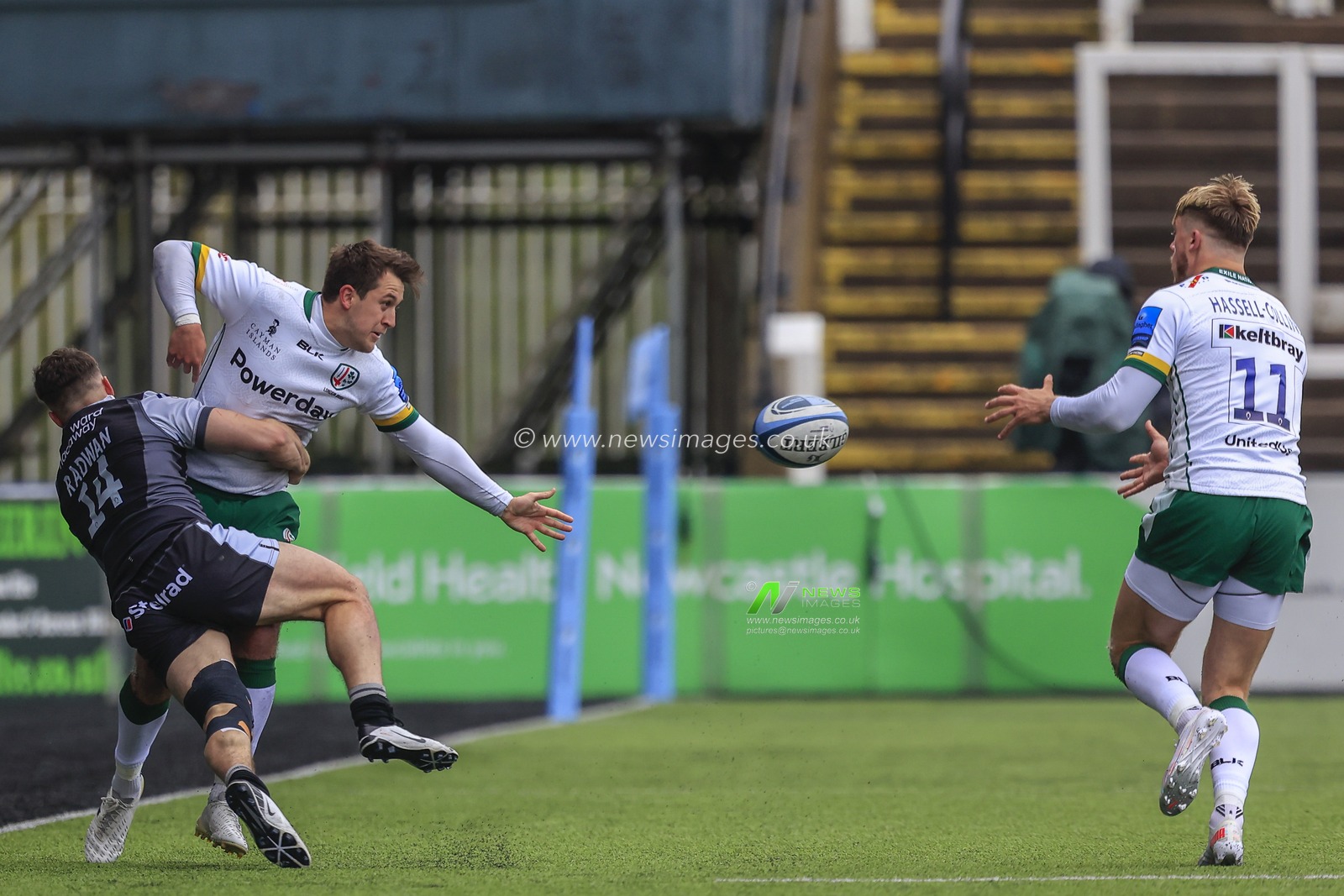 Tom Parton of London Irish, being tackled by Adam Radwan of Newcastle Falcons, passes the ball to Ollie Hassell-Collins of London Irish