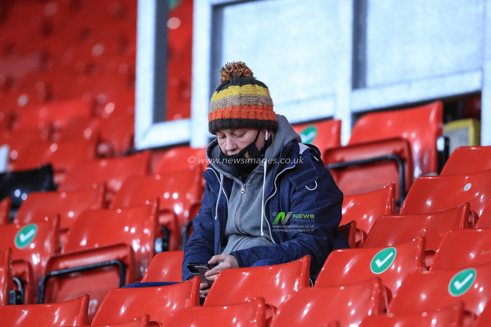A Liverpool fan sits in the cop as fans return to Anfield