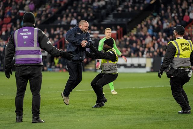 A pitch invader celebrates Yuki Ohashi of Blackburn Rovers scoring to make it 0-2 as security tries to remove him from the pitch during the Sky Bet Championship match Sheffield United vs Blackburn Rovers at Bramall Lane, Sheffield, United Kingdom on 22 April 2026

(Photo by Maynard Manyowa/News Images)