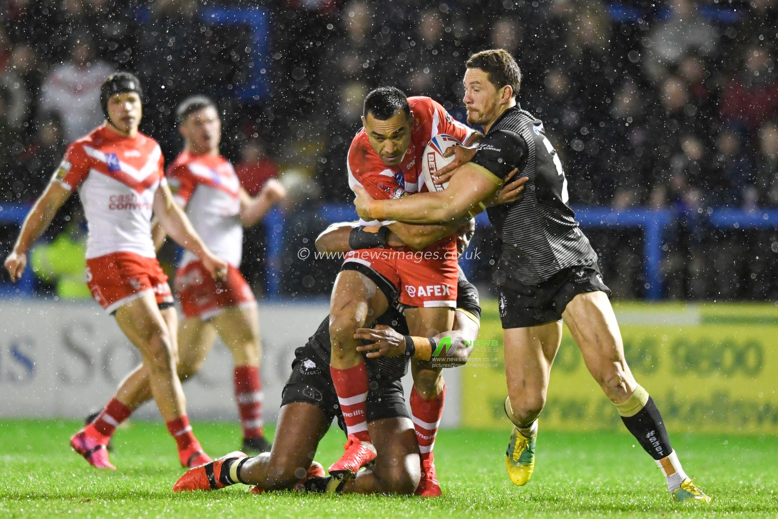 29th February 2020, Halliwell Jones Stadium, Warrington, England; Betfred Super League, Toronto Wolfpack v Saint Helens : Zeb Taia (11) of St Helens is tackled by Sonny-Bill Williams (21) and Gadwin Springer (15) of Toronto Wolfpack