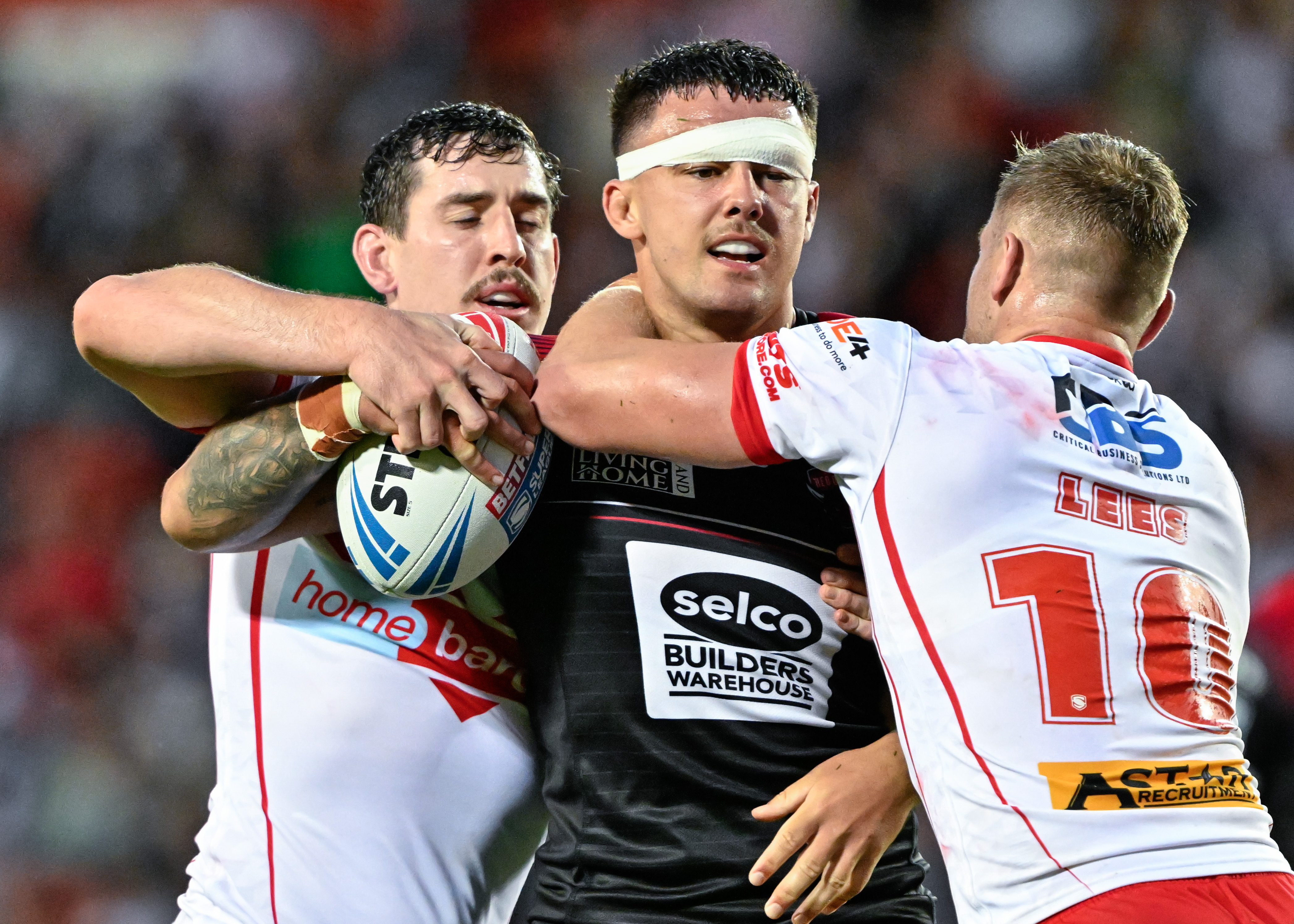 Oli Partington of Salford Red Devils gets tackled during the Betfred Super League Round 21 match St Helens vs Salford Red Devils at Totally Wicked Stadium, St Helens, United Kingdom, 8th August 2024  (Photo by Cody Froggatt/News Images)